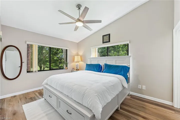 Bedroom featuring vaulted ceiling, wood finished floors, and ceiling fan