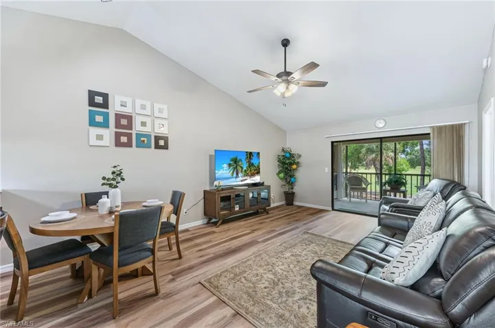 Living room featuring high vaulted ceiling, light wood finished floors, and ceiling fan