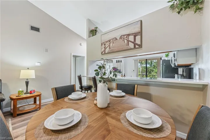 Dining space featuring wood finished floors and high vaulted ceiling