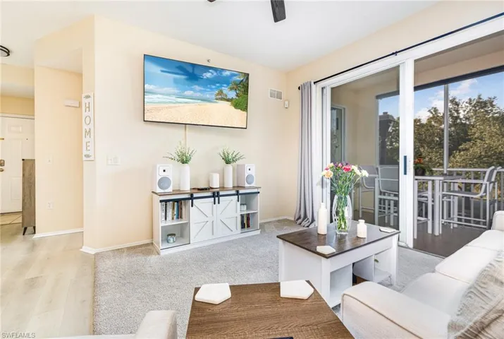 Living area with sliding glass doors opening to a screened balcony