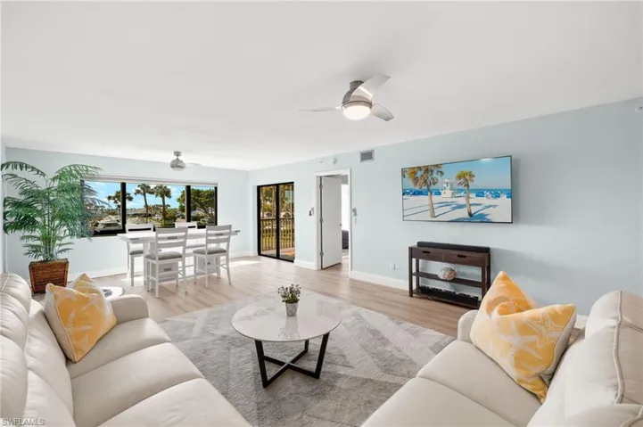 Living area with baseboards, light wood-style floors, visible vents, and ceiling fan