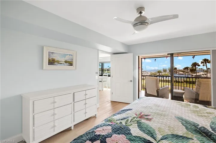 Bedroom with a ceiling fan, access to outside, baseboards, and light wood-type flooring