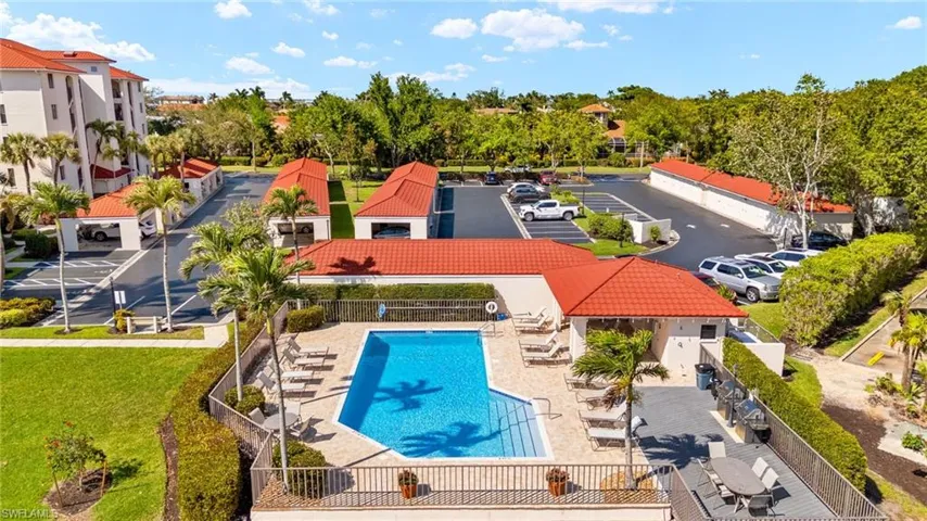 Community pool with a patio, a yard, fence, and a residential view