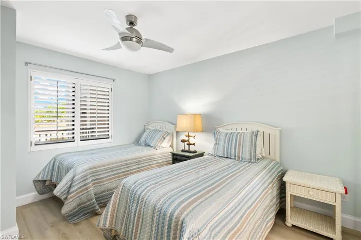 Bedroom featuring baseboards, wood finished floors, and a ceiling fan