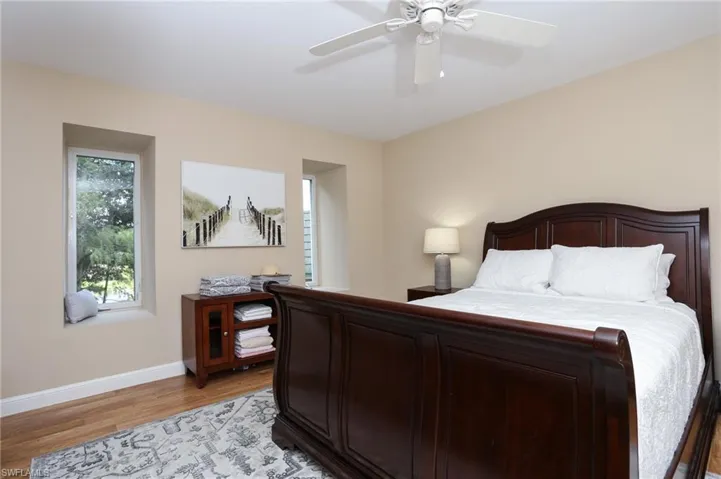 Bedroom with light wood-style flooring, baseboards, and a ceiling fan