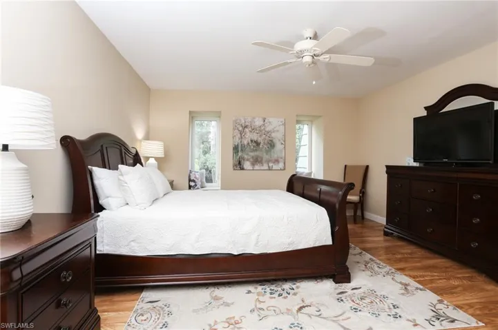 Bedroom featuring a ceiling fan, baseboards, and light wood-style floors