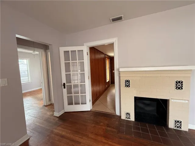 Unfurnished living room featuring dark wood-style floors and a fireplace