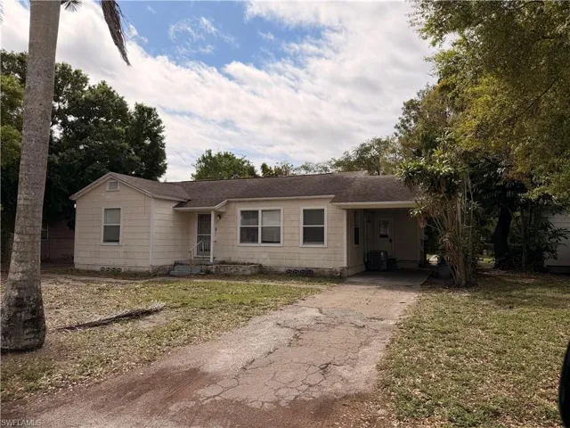 Single story home featuring a front yard, crawl space, asphalt driveway, and an attached carport