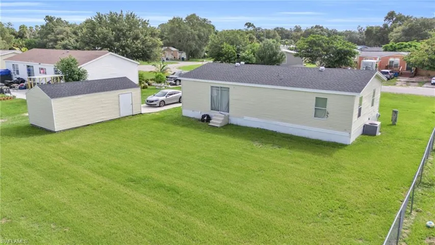 Back of house featuring a storage shed and a lawn