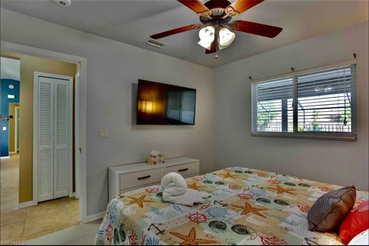 Bedroom featuring light tile patterned floors, ceiling fan, and baseboards