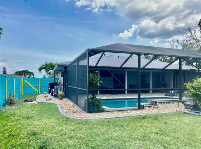 Rear view of property with an outdoor pool and a patio