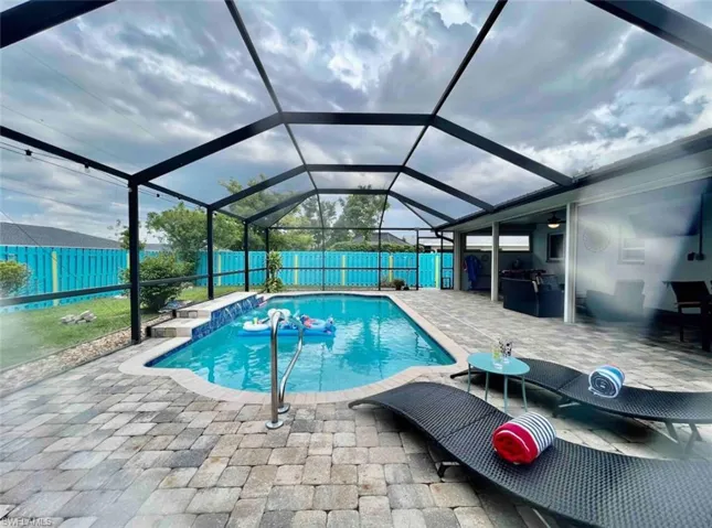 View of pool featuring a patio area, a fenced backyard, and a lanai