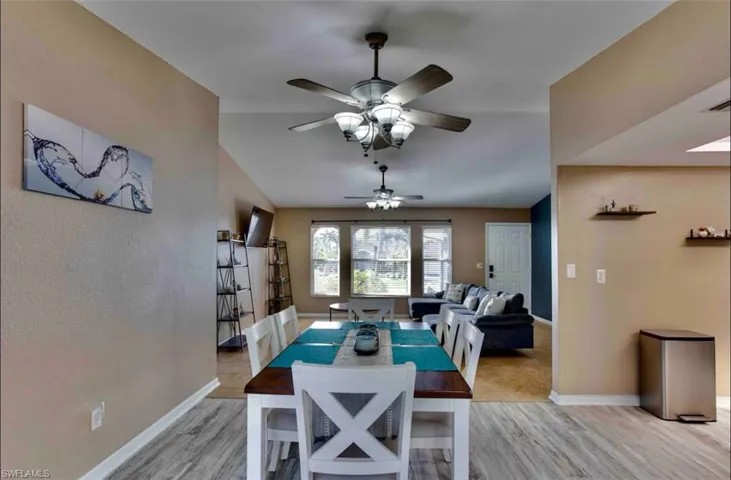 Dining room with light wood finished floors, ceiling fan, and baseboards