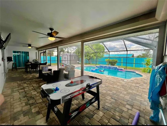 View of swimming pool featuring outdoor dining area, a storage shed, a ceiling fan, a patio, and a fenced backyard