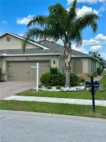 View of front facade with a garage and a front lawn