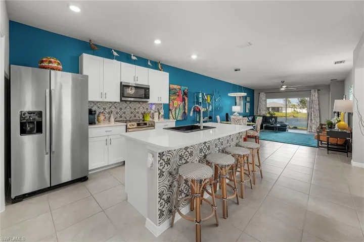Kitchen featuring a kitchen island with white cabinets, and stainless steel appliances