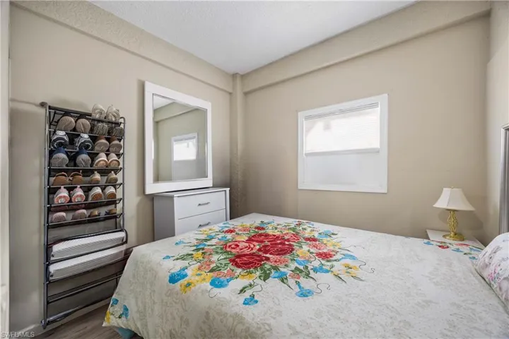 Bedroom featuring dark wood finished floors, multiple windows, and a textured ceiling