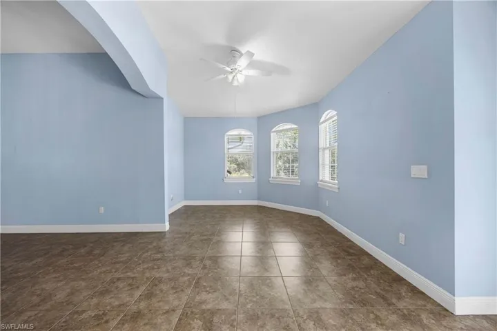 Spare room featuring a ceiling fan and dark tile patterned floors