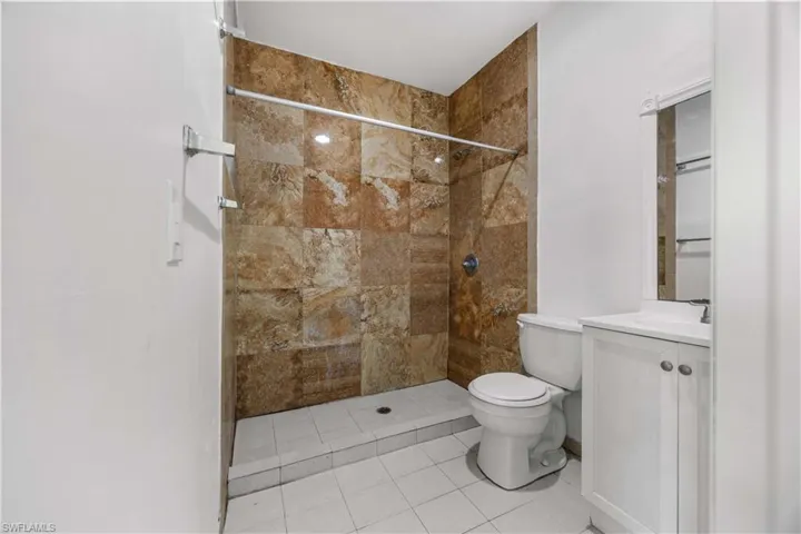 Full bath featuring vanity, a shower stall, and light tile patterned flooring