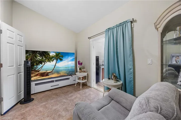 Living area with lofted ceiling and light tile patterned floors