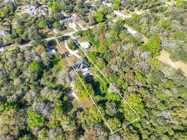 Aerial view of property and surrounding area featuring property parcel outlined