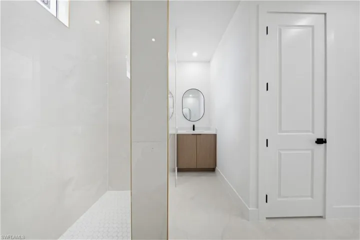Bathroom featuring vanity, walk in shower, and recessed lighting