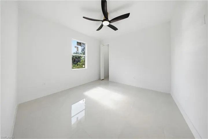 Empty room featuring ceiling fan and baseboards