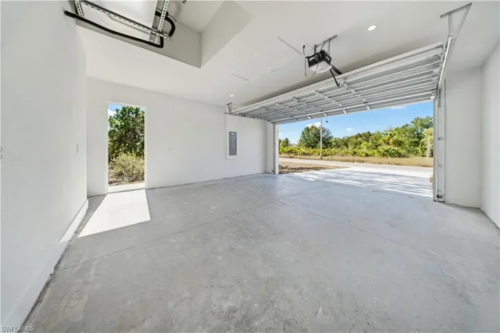 Garage featuring electric panel and a garage door opener