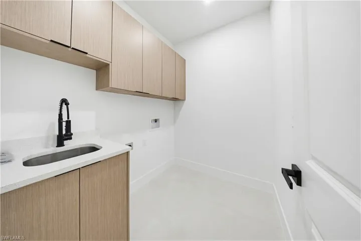 Washroom featuring hookup for a washing machine and cabinet space