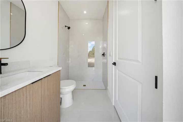 Bathroom with a marble finish shower and vanity