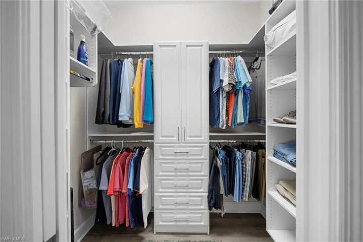 Walk in closet with wood finished floors