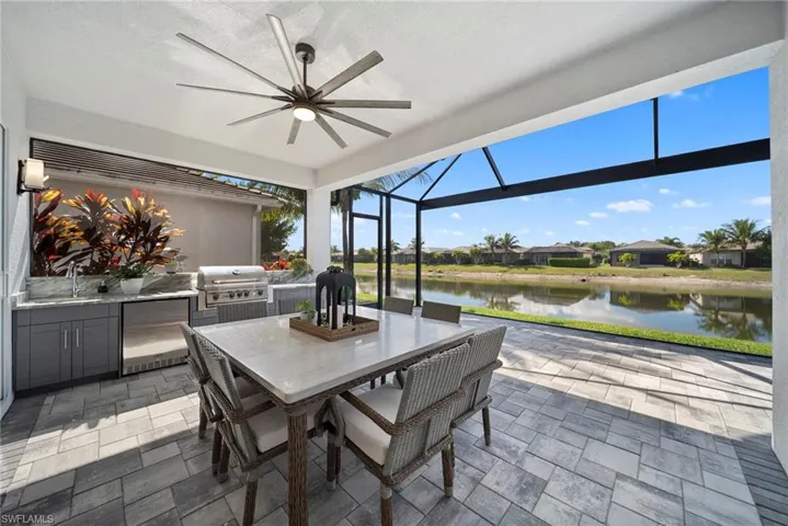 View of patio with an outdoor kitchen / dining area, a sunroom, ceiling fan, a lanai, and a residential view