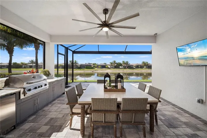 View of patio with an outdoor kitchen / dining area, ceiling fan, a sunroom, a residential view, and a lanai