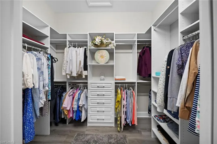 Walk in closet featuring dark wood-type flooring