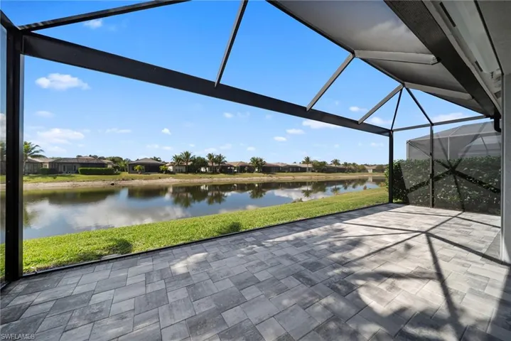 View of patio with a lanai, a sunroom, a residential view, and a water view ROOM FOR A POOL!