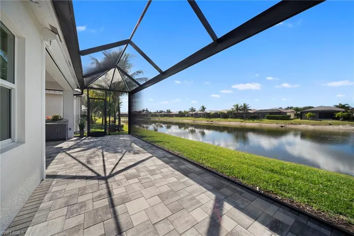 View of patio / terrace featuring a sunroom, a lanai, a water view, and a residential view