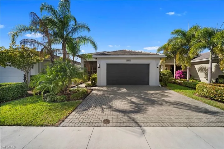 Single story home featuring decorative driveway, a garage, and stucco siding