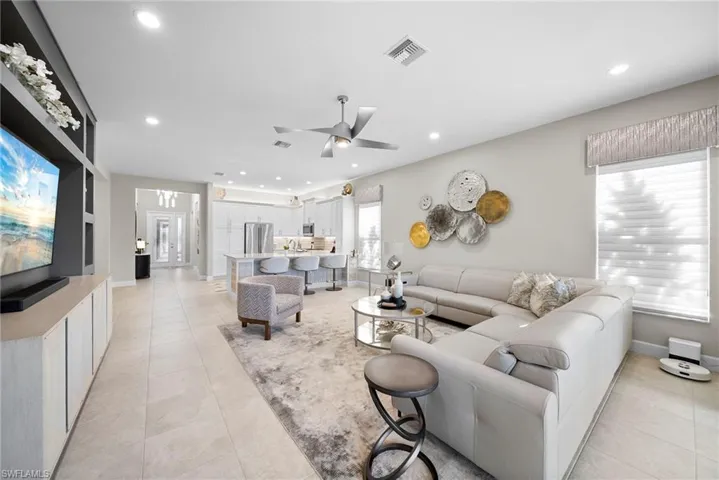 Living area featuring a ceiling fan, light tile patterned floors, and recessed lighting
