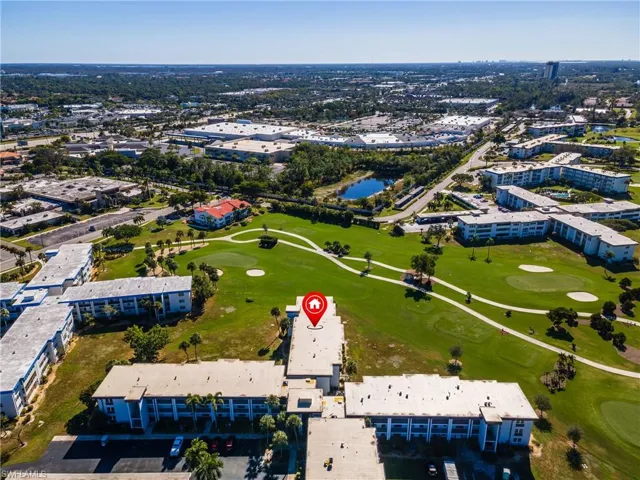 Surrounding golf course, multiple building structures, and paved parking areas
