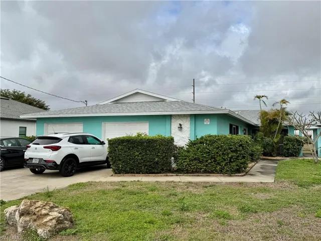 View of side of property with a shingled roof, an attached garage, stucco siding, concrete driveway, and a lawn
