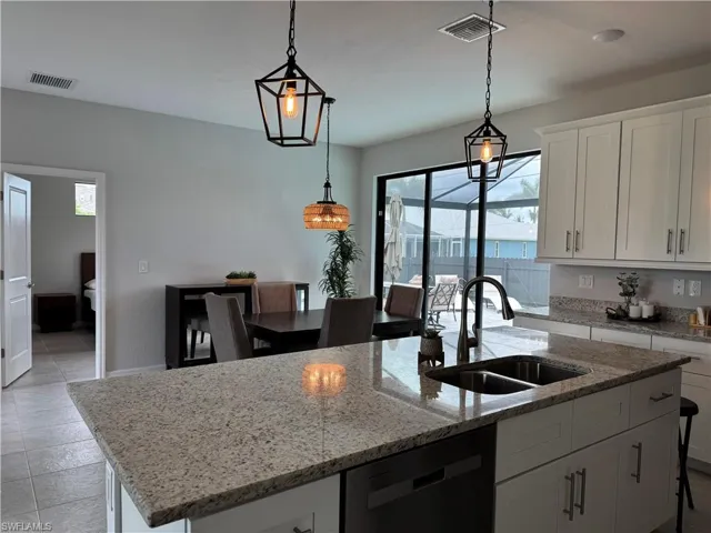 Kitchen island with a double basin sink, brushed nickel faucet, and granite countertop