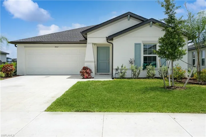 Ranch-style house with a garage and a front lawn