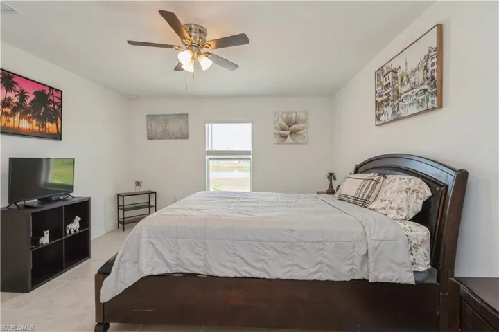 Tiled bedroom featuring ceiling fan