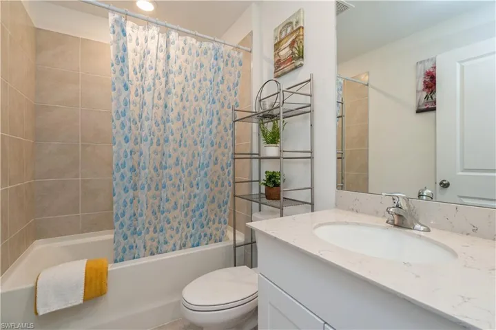 Full bathroom featuring oversized vanity, toilet, and shower / tub combo