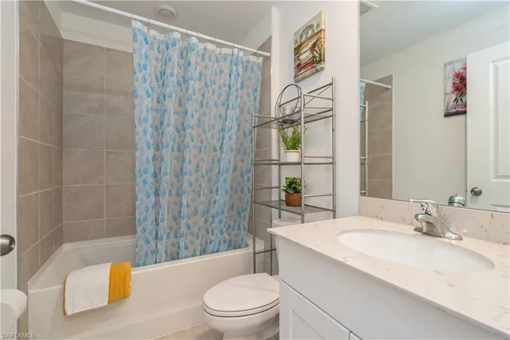 Full bathroom featuring shower / bath combo, oversized vanity, and toilet