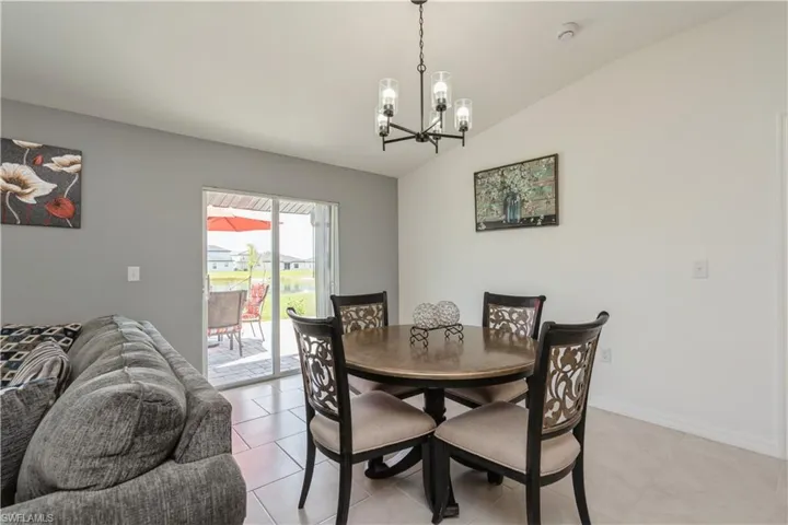 Tiled dining area featuring a chandelier and lofted ceiling