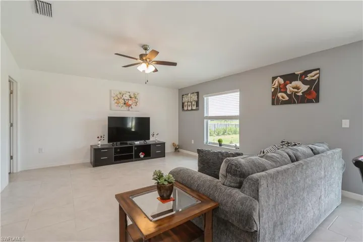 Tiled living room featuring ceiling fan