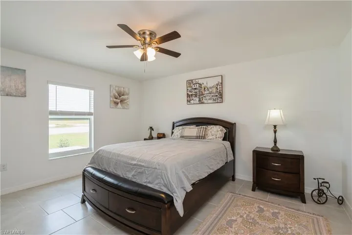 Bedroom featuring ceiling fan and light tile floors