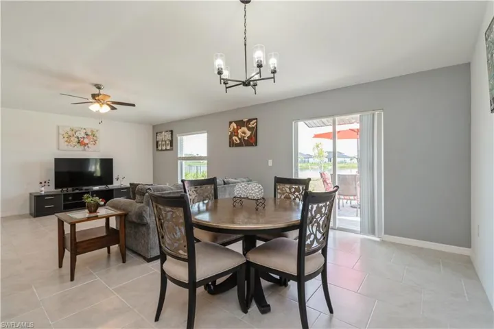 Dining room featuring light tile floors and ceiling fan with notable chandelier