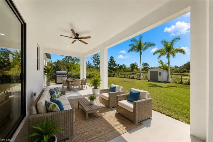 Spacious covered patio featuring a ceiling fan, outdoor dining area, and concrete flooring